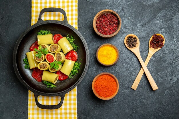 Top view cooked italian pasta with meat and different seasonings on grey space