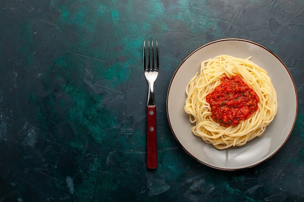 진한 파란색 표면에 다진 고기와 토마토 소스를 곁들인 상위 뷰 요리 이탈리아 파스타