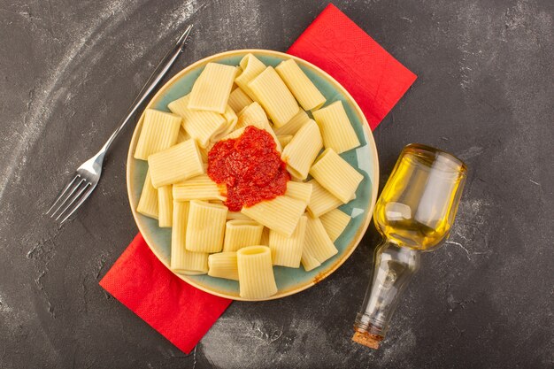 A top view cooked italian pasta with tomato sauce inside plate dish