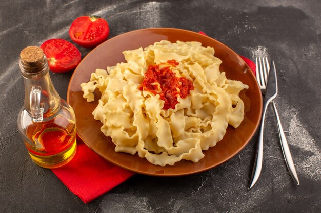 平面図は、灰色のテーブルフード食事イタリアンパスタにカトラリーとトマトのプレート内トマトソースのイタリアンパスタを調理