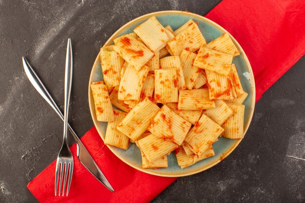 Вид сверху приготовленные итальянские макароны с томатным соусом внутри тарелки