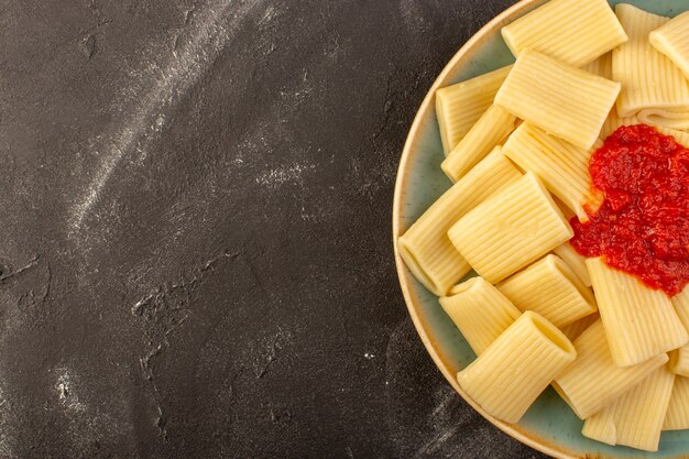 A top view cooked italian pasta with tomato sauce inside plate