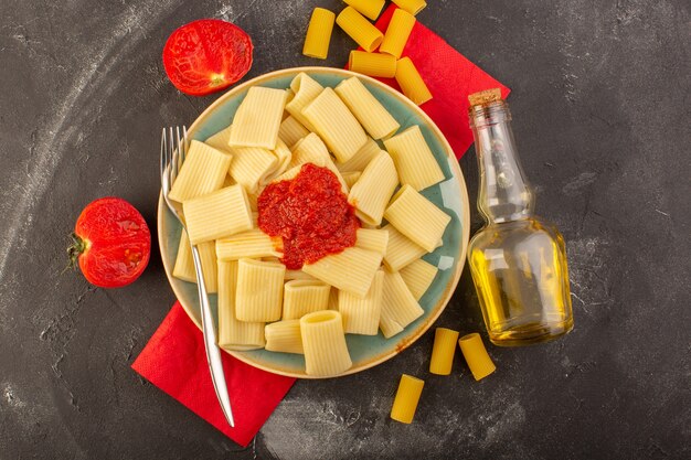 Вид сверху приготовленные итальянские макароны с томатным соусом внутри тарелки