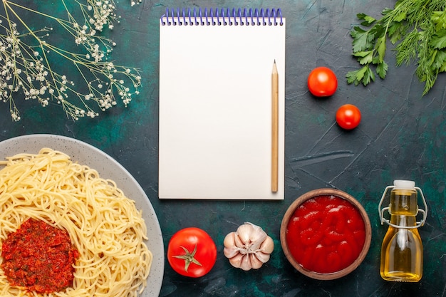 Top view cooked italian pasta with tomato sauce minced meat and oil on blue surface