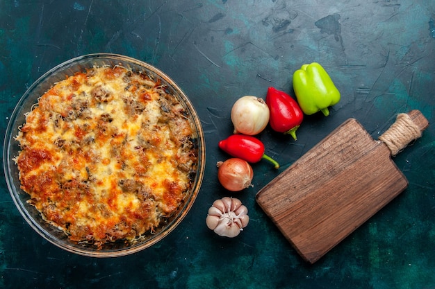 Top view cooked meat meal with sliced meat along with cheese and fresh vegetables on dark-blue desk food meat meal dish dinner oven bake