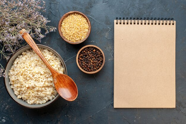 Top view cooked pearl barley with notebook