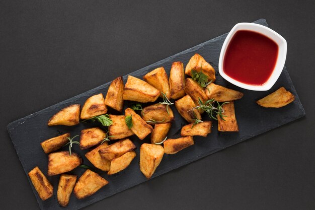 Top view cooked potatoes with ketchup in bowl