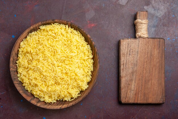 Top view cooked rice delicious meal inside brown plate on dark space