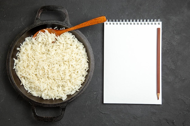 Top view cooked rice inside pan with notepad on dark surface dinner meal food rice eastern