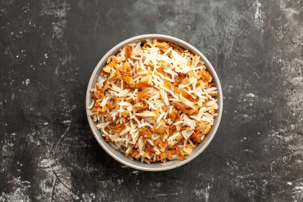 Вид сверху приготовленный рис внутри тарелки на темной поверхности блюдо восточная еда еда темная