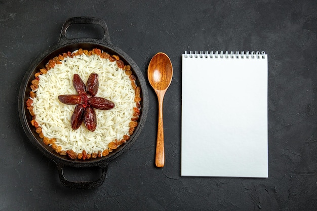 Free photo top view cooked rice with seasonings and raisins on a dark surface meal food rice eastern dinner