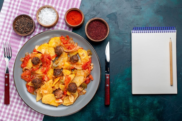 Free photo top view cooked sliced potatoes with meatballs along with seasonings on the dark blue desk.