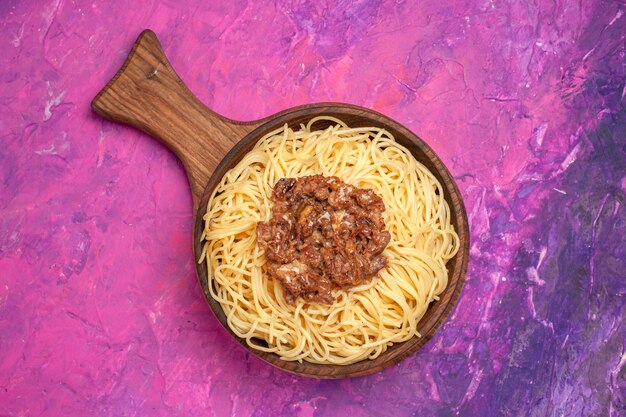 無料写真 上面図ピンクのテーブル生地皿パスタ調味料にひき肉と調理されたスパゲッティ