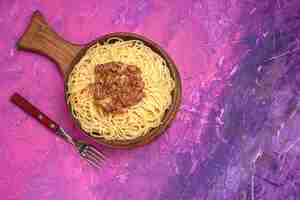 Foto gratuita spaghetti cucinati vista dall'alto con carne macinata sul condimento per piatti di pasta rosa da tavola