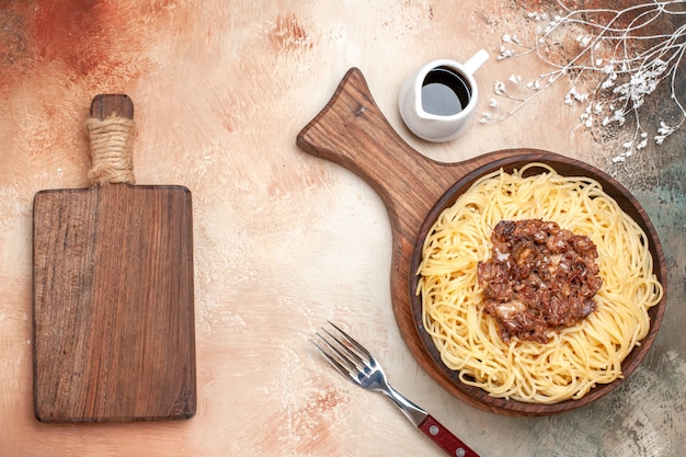 Foto gratuita spaghetti cucinati vista dall'alto con carne macinata su pasta di pasta piatto da scrivania in legno