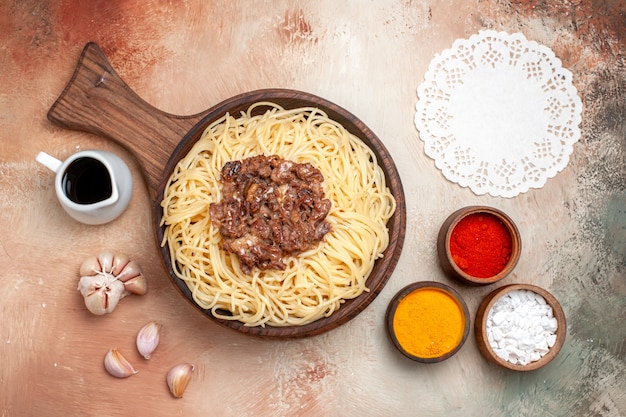 Spaghetti cucinati vista dall'alto con carne macinata su condimento per piatti di pasta da scrivania in legno