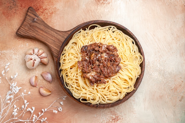 Spaghetti cucinati vista dall'alto con carne macinata su condimenti per piatti di pasta per pasta con pavimento in legno