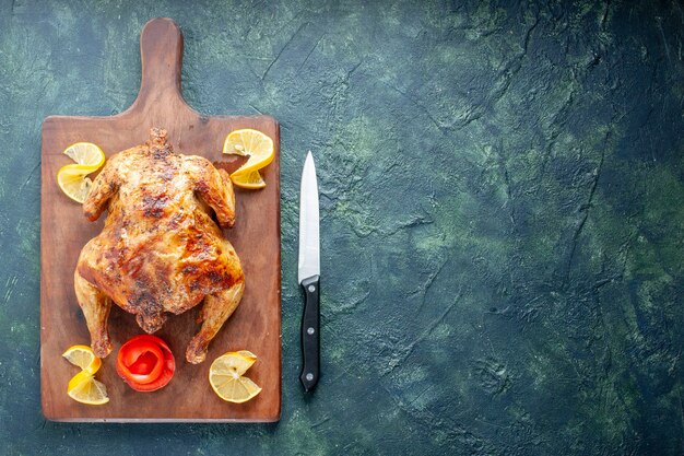 Top view cooked spiced chicken with lemon on dark surface