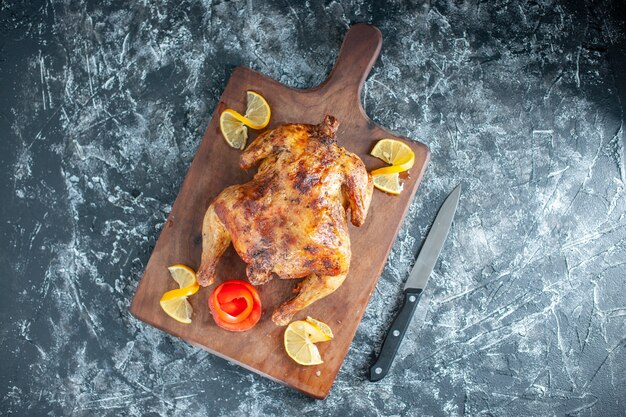 Top view cooked spiced chicken with lemon on a light gray surface