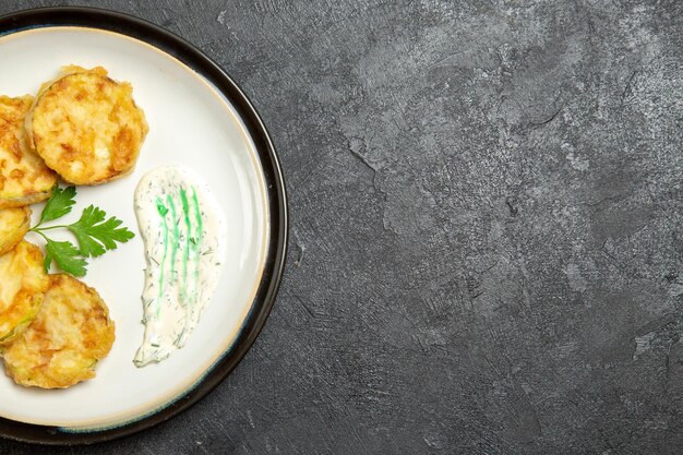 Top view of cooked squashes slices inside plate on a grey surface