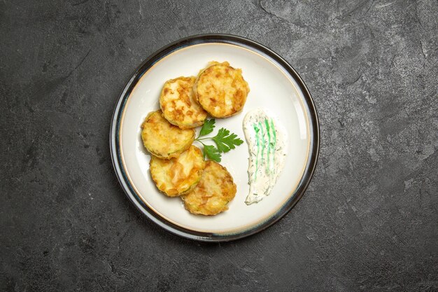 Top view of cooked squashes slices inside plate on grey surface