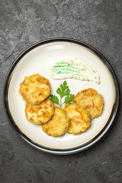 Top view of cooked squashes slices inside plate on grey surface