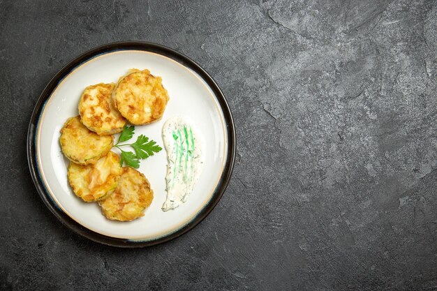 Top view of cooked squashes slices inside plate on grey surface