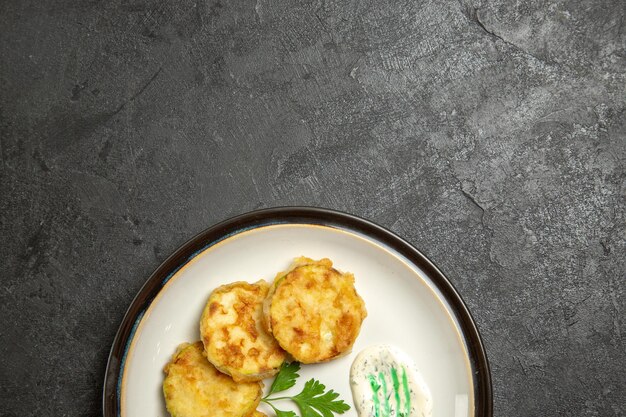 Top view of cooked squashes slices inside plate on grey surface