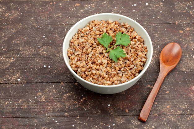 Top view cooked tasty buckwheat inside plate on dark