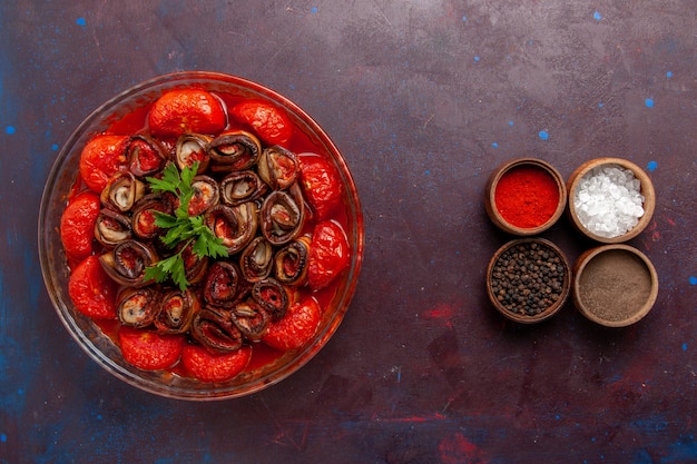 Vista dall'alto farina di verdure cotte deliziosi pomodori e melanzane con condimenti sul pavimento scuro che cucinano cibo pasto cena piatto