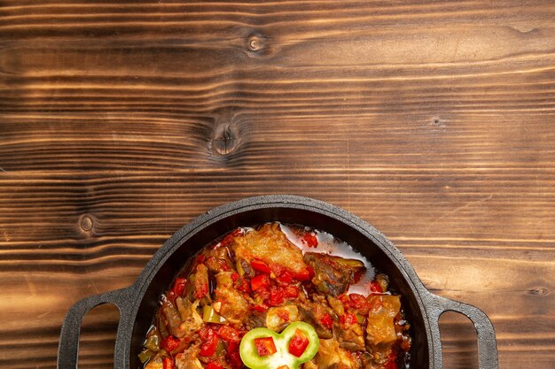 Top view cooked vegetable meal inside pan on wooden desk