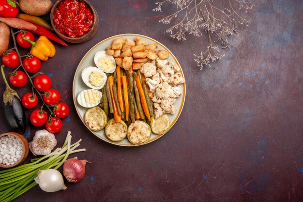 Top view cooked vegetables with egg meal and fresh vegetables on dark desk