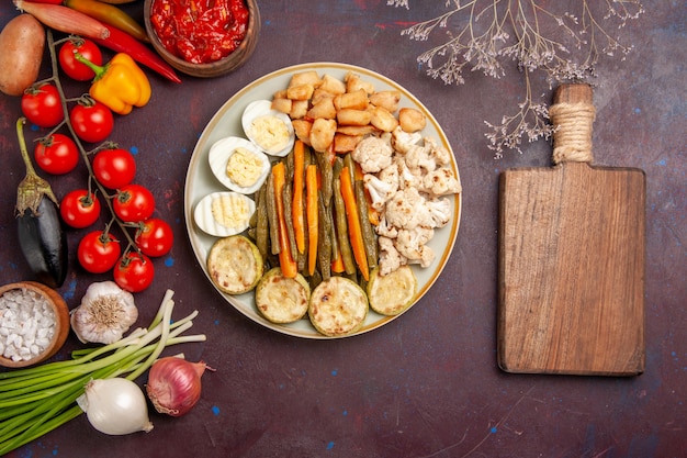 Top view cooked vegetables with egg meal and fresh vegetables on dark floor meal food lunch vegetable product