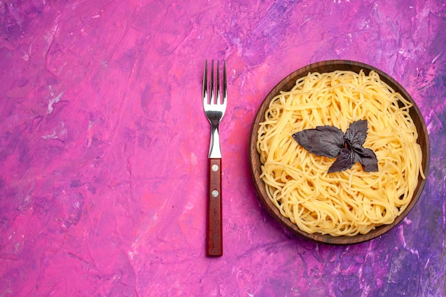 Top view cooked yummy spaghetti inside plate on pink desk meal pasta dough dish