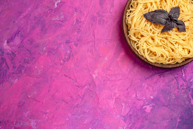 Top view cooked yummy spaghetti inside plate on the pink table meal pasta dough dish