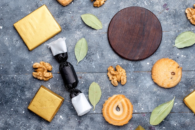 Free photo top view of cookie and walnuts along with chocolate cake on grey desk, cookie biscuit chocolate cocoa