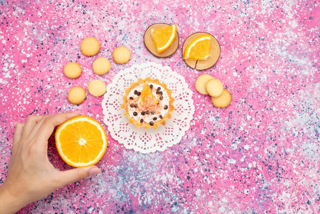 Top view cookies and cake with orange slices female taking orange on the colored surface cookie biscuit fruit cake sweet