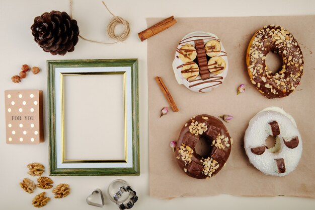 Top view of cookies with cinnamon and walnuts and pinecone and frame on white with copy space
