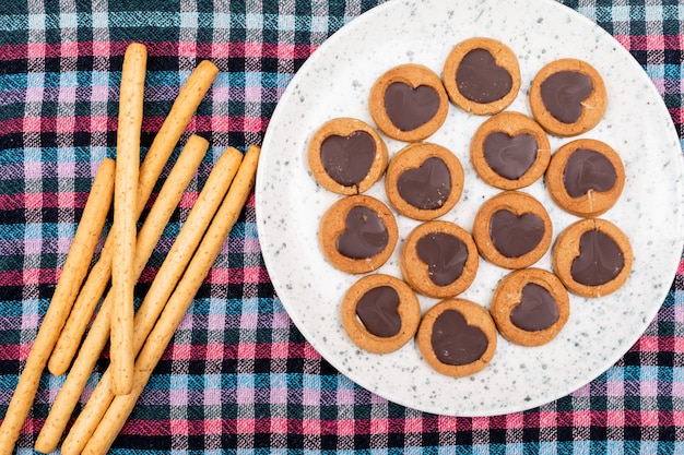 top view cookies with heart shaped chocolate in plate