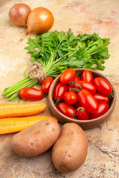 ローマトマト、ジャガイモ、タマネギ、ニンジン、木製の背景にサラダ用のパセリの束とトップビューの調理材料の概念