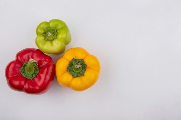 Top view  copy space colored bell peppers on white background