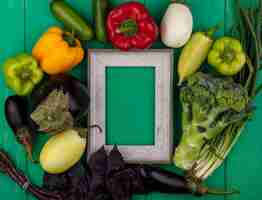 Free photo top view  copy space gray frame with basil  bell peppers  eggplant  cucumber  green onion and broccoli on green background