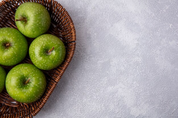 Top view  copy space green apples in a basket on a white background