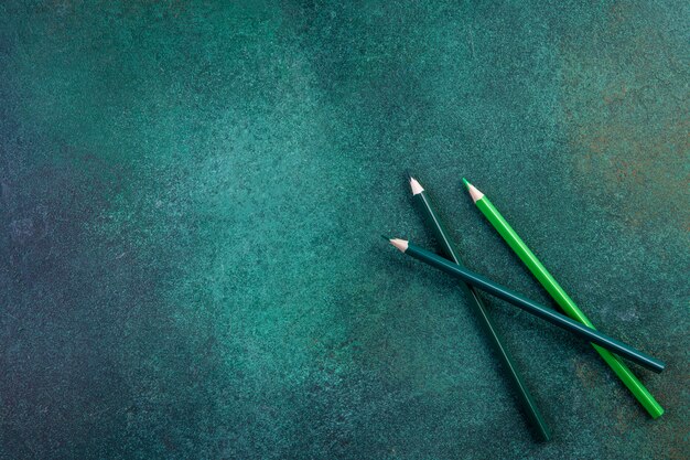 Вид сверху копией пространства зелеными карандашами на зеленом фоне
