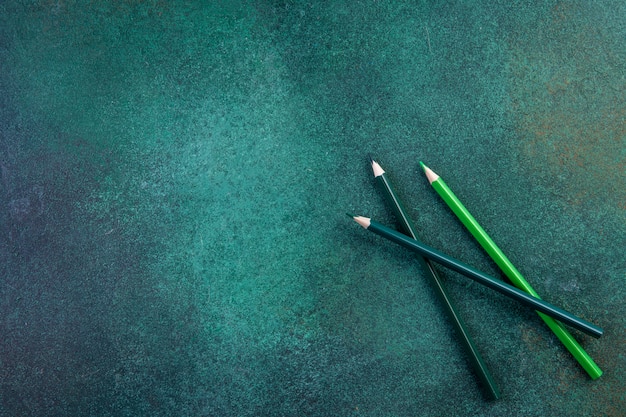 Top view copy space green pencils on a green background