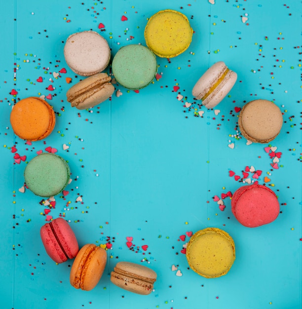Free photo top view copy space multicolored macarons on a blue background