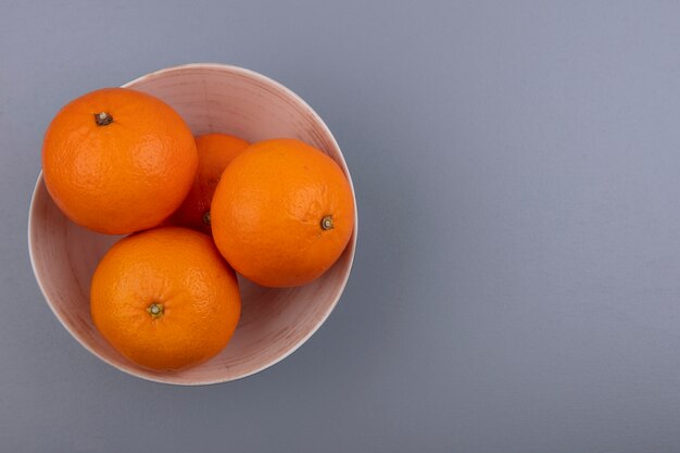 Top view  copy space oranges in bowl on gray background