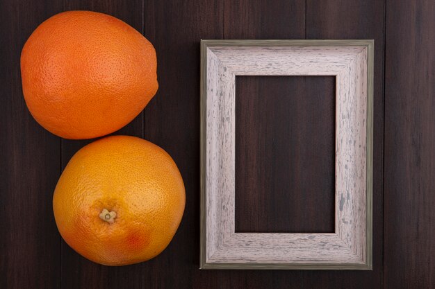 Top view  copy space oranges with gray frame on wooden background