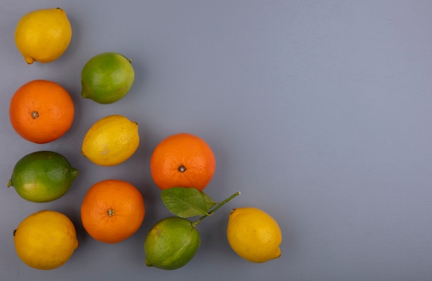 Top view  copy space oranges with lemons and limes on gray background