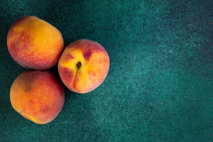 Free Photo top view copy space peaches on green